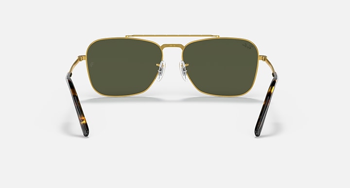 Gold rectangular sunglasses with dark green lenses and curved black-tipped temples