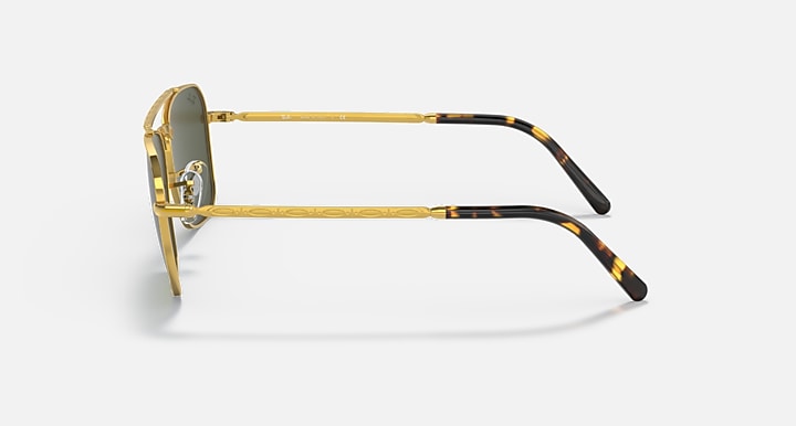 Gold sunglasses with patterned tortoiseshell-like temple arms and dark lenses
