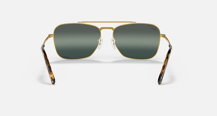 Caravan-style sunglasses with gold frame and dark green rectangular lenses, front view