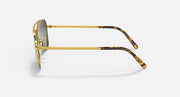 Caravan-style sunglasses, side view with gold frame, patterned tortoise temple tips, green lenses