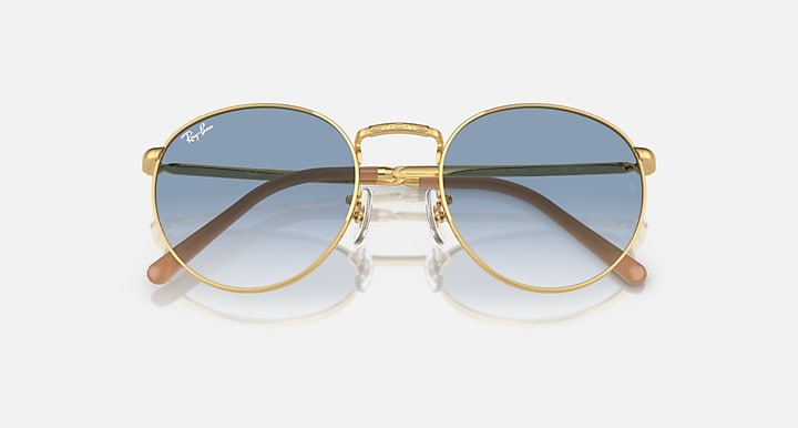 Gold-tone round sunglasses with blue gradient lenses and wide angular brow bar