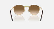Gold-tone round sunglasses with brown gradient lenses, front view with mirrored reflection