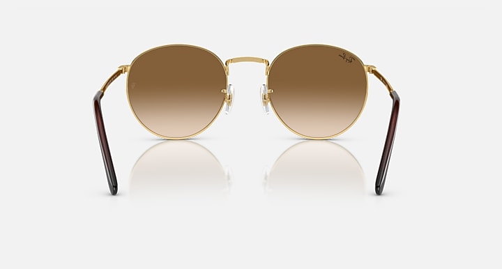 Gold-tone round sunglasses with brown gradient lenses, front view with mirrored reflection