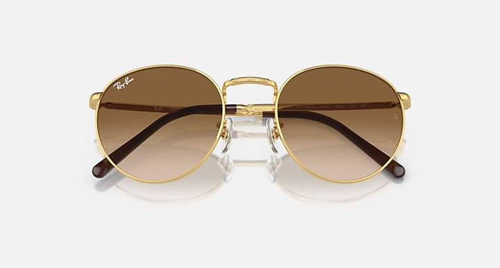 Gold-tone round sunglasses with brown gradient lenses and dark bar across the top