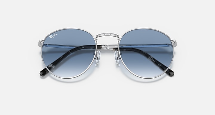 Ray-Ban round sunglasses angled front with blue gradient lenses and dark temple accents