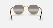 Round gold metal sunglasses front view with dark gray tinted lenses and curved temples
