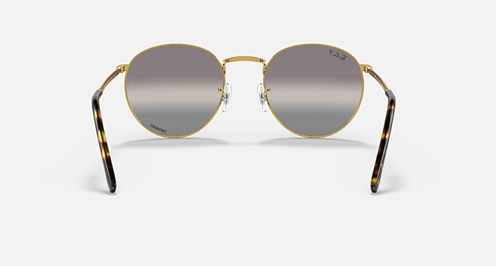 Round gold metal sunglasses front view with dark gray tinted lenses and curved temples