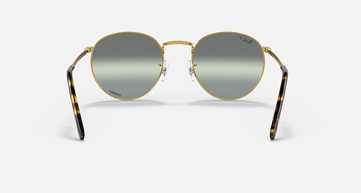 Round gold metal sunglasses front view with dark gray lenses and patterned side arms