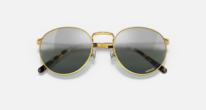 Round gold metal sunglasses with dark tinted lenses and patterned temple arms