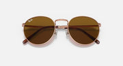 Ray-Ban round sunglasses angled front with rose-gold frame and brown gradient lenses