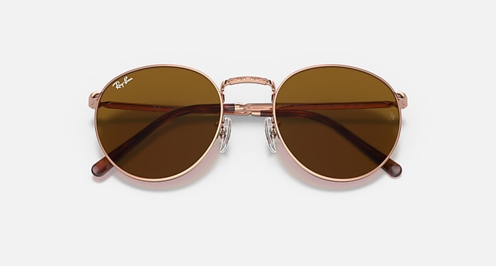 Ray-Ban round sunglasses angled front with rose-gold frame and brown gradient lenses
