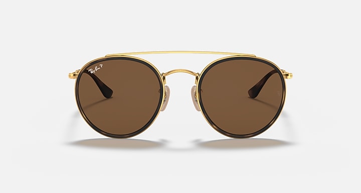Round sunglasses with gold metal frame and dark brown gradient lenses, double bridge.