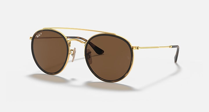 Round sunglasses with gold metal frame and dark brown lenses, double bridge style.