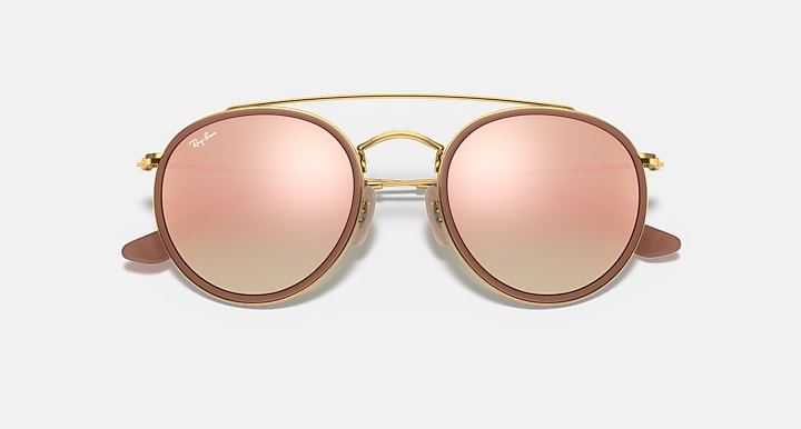 Round sunglasses with gold metal frame and rose pink lenses, double bridge and nose bridge cutout.