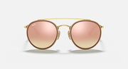 Round sunglasses with gold metal frame and soft pink gradient lenses, double bridge detail.