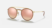 Round sunglasses with gold metal frame and pink gradient mirrored lenses, double bridge.