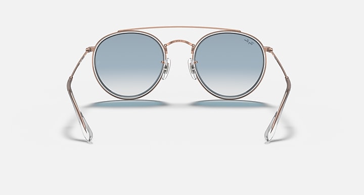 Rose-gold round sunglasses with blue mirrored lenses, front stand view