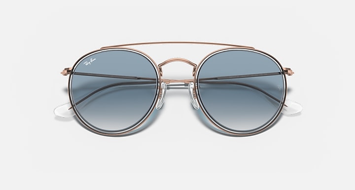 Round metal sunglasses with rose-gold frame and dark blue lenses, double-bridge front