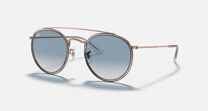 Round metal sunglasses with rose-gold frame and blue mirrored lenses, double-bridge detail
