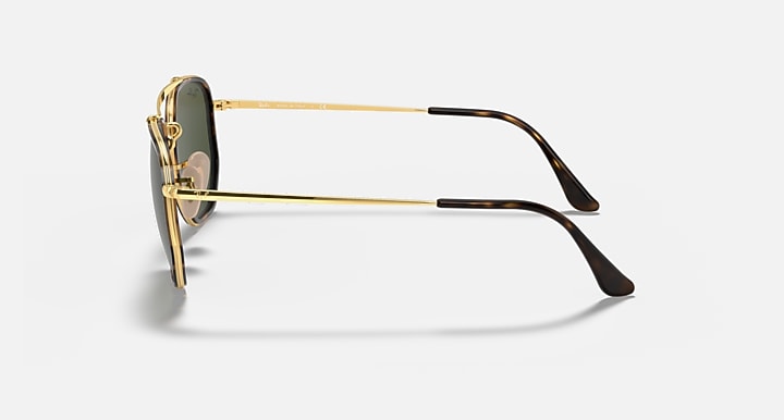 Gold hexagonal sunglasses showing side profile with dark green lens and metal arm
