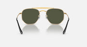 Hexagonal sunglasses with gold frame, dark green lenses, and black temple arms