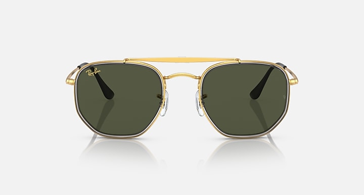 Hexagonal sunglasses with gold frame and dark green lenses