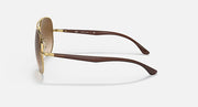 Ray-Ban aviator sunglasses with gold frame and warm brown gradient lenses, side view
