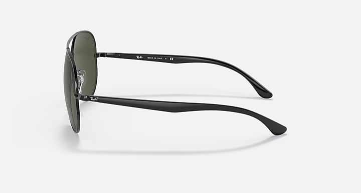 Ray-Ban aviator sunglasses with dark green lens and black metal frame, side profile view.
