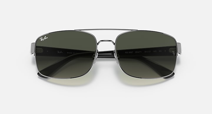 Top view of silver-toned sunglasses with dark tinted lenses and small branding near hinges.