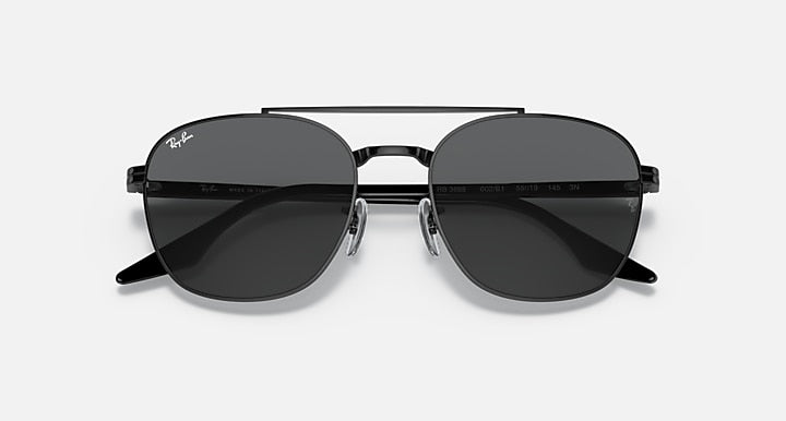Round sunglasses with dark gray lenses and black frame, angled front view