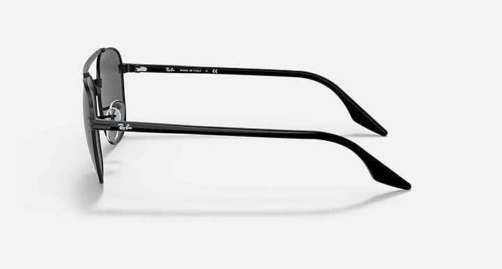 Round sunglasses, black metal frame and dark lenses, side profile with logo detail