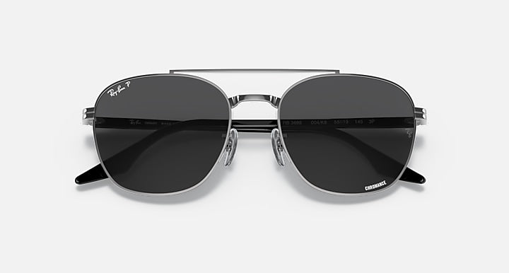 Round sunglasses with dark gray lenses and black metal frame, front close-up