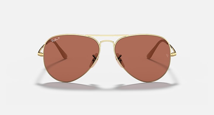 Gold aviator sunglasses with brown tinted lenses, teardrop shape, and bridge detail