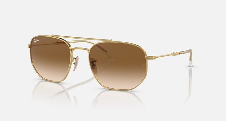 Gold-tone sunglasses with brown gradient lenses and clear side temples
