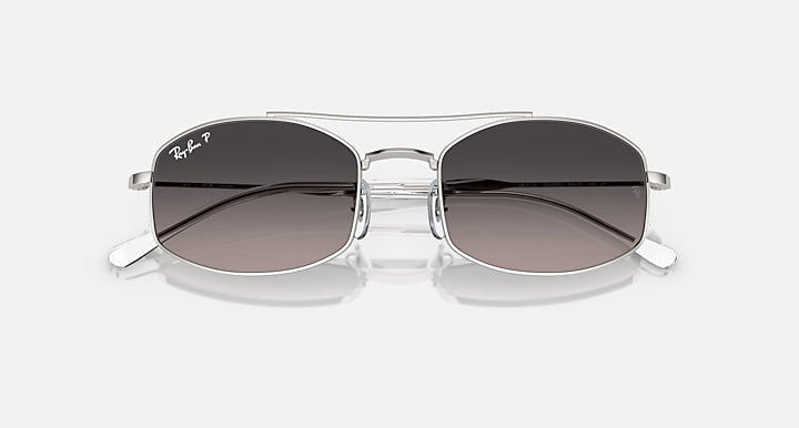 Ray-Ban sunglasses with dark gradient lenses and clear frame with silver accents