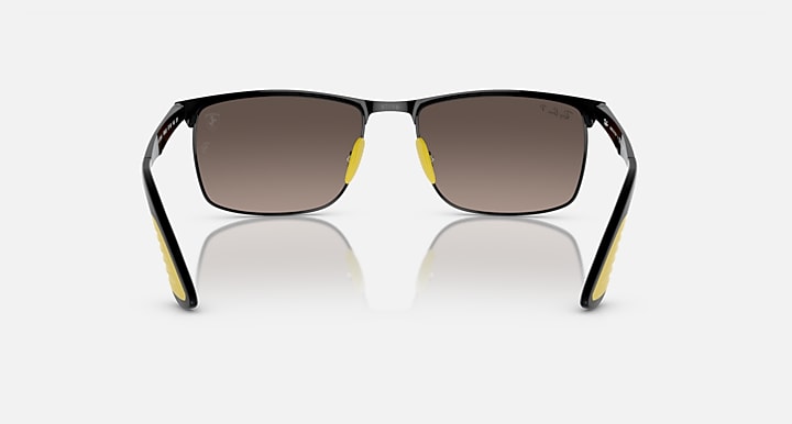 Black sunglasses with dark lenses, yellow accents, and visible metal hinges