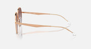 Side view of round sunglasses with rose gold metal frame and dark gradient lenses