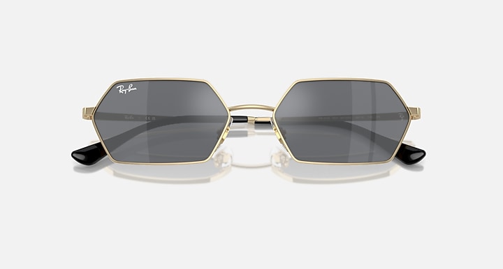 Hexagonal dark mirrored sunglasses front view with gold frame and Ray-Ban logo