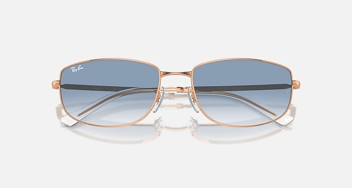 Rose gold sunglasses with blue gradient lenses and rounded rectangular shape