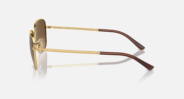 Gold-tone aviator sunglasses with clear temples and dark brown temple tips