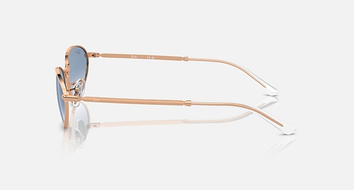 Gold-tone sunglasses side view with blue tinted lenses and clear temples