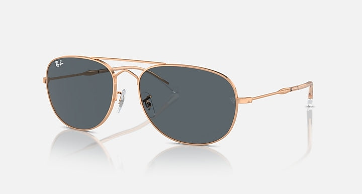Ray-Ban aviator-style sunglasses with rose-gold frame and dark oval lenses