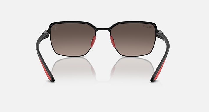 Front view of square sunglasses with black frames and dark tinted lenses, red details