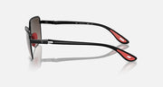 Side view of black square sunglasses with dark lenses and red temple accents