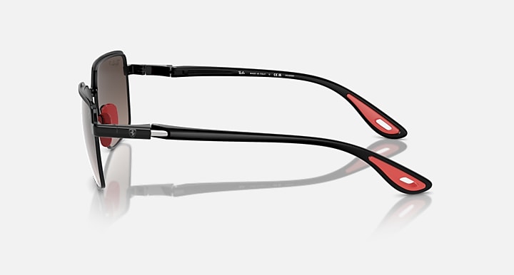 Side view of black square sunglasses with dark lenses and red temple accents
