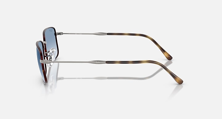 Side-profile sunglasses with dark blue lens, silver arms and tortoise brown temple