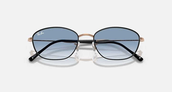 Sunglasses with blue tinted lenses and rose-gold/black metal frames, front view.