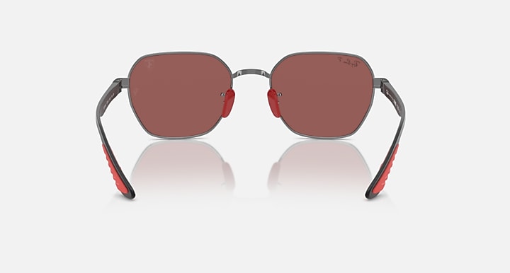 Sunglasses with dark gray frame and rose-brown lenses, red inner arms, oval profile.