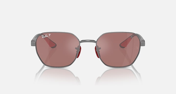 Sunglasses with dark gray frame and rose-tinted lenses, oval shape, metal bridge.