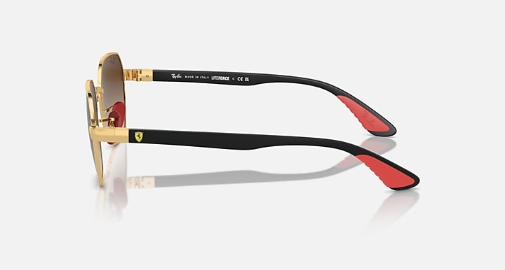 Sunglasses side view with gold frame, black temple band, red accent on temple tip.